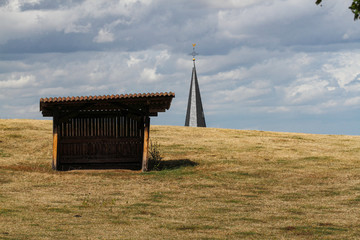 Church tower behind a field with a shelter