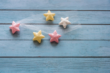 Many colorful props stars placed on blue wooden boards to form a fashion dream copy space