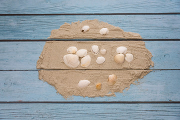 Blue striped wooden boards stacked with sand and white shells to form a retro creative dream copy background