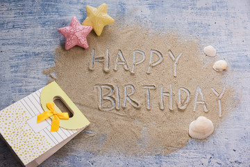 Happy birthday greeting card background top view composed with sand and ornaments