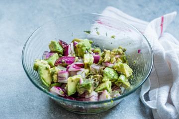 Avocado Salad with Red Onions in Glass Bowl.