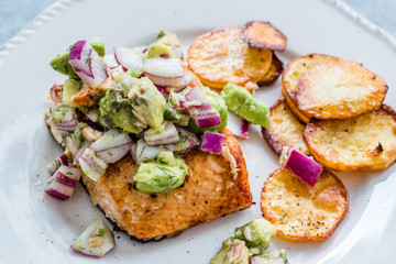 Salmon Fish Fillet with Avocado, Red Onions and Baked Round Potato Slices in Seafood Plate.