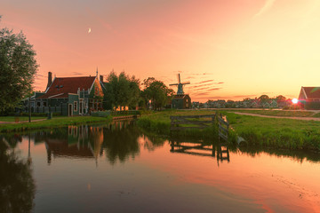 Fototapeta premium Sunset over the Zaanse Schans calm and flat canal water