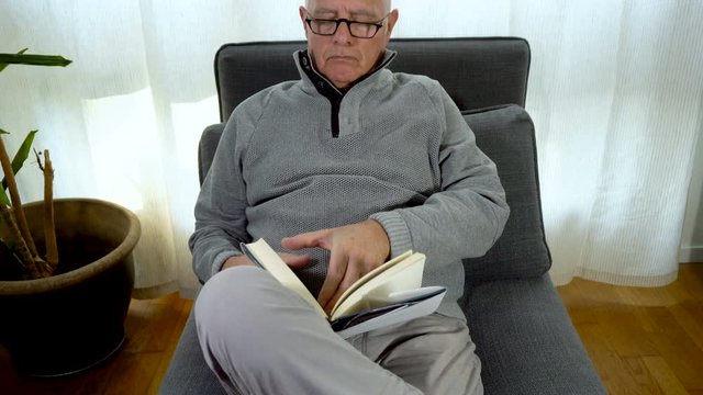 Elderly Glasses Man Reading Book At Home