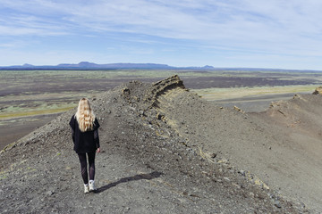Iceland Crater landscape. Young woman traveller on the top of the crater  © olarty