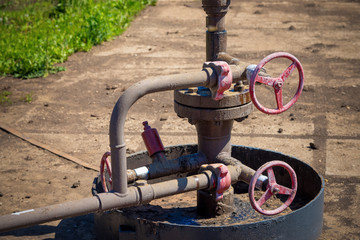 Oil and gas processing plant with pipe line valves. Oil pipeline valves in the oil and gas industry. Valve plug an oil pipeline in the field on a sunny summer day.