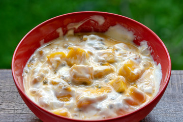 Mango, passionfruit and yogurt brulee. Fruit dessert on breakfast with wedges of perfectly ripe in season mangoes covered fresh passion fruit pulp