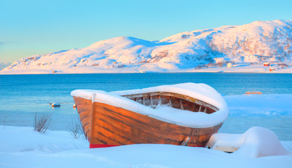 Beautiful winter landscape with snow covered green house - Red wooden boathouse covered with layers...
