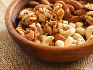 walnuts, cashews and almonds in a wooden plate. healthy foods