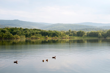 beautiful summer lake against the background of high mountains and blue sky