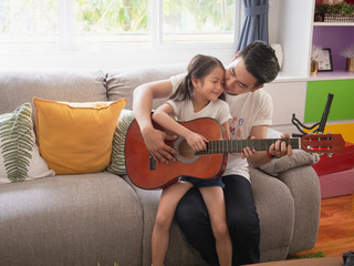 Obraz premium Father is teaching his daughter to play guitar