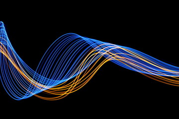 Long exposure, light painting photography.  Vibrant streaks of electric blue and metallic gold color, against a black background.