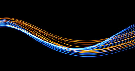 Long exposure, light painting photography.  Vibrant streaks of electric blue and metallic gold color, against a black background.