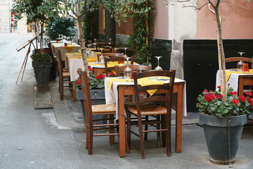 table setting on the street from a rustic restaurant in the old town of the capital city La Spezia, Liguria, Italy
