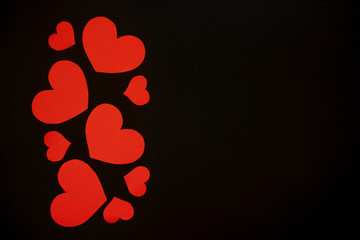 Red paper hearts on black background