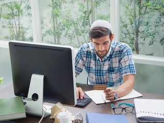 young man working at home  with Health insurance card  ,businessman works on his computer to get all his business