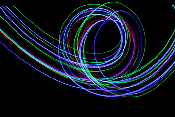 Long exposure, light painting photography.  Vibrant streaks of neon multi color against a black background.