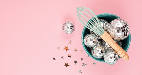Flat lay with disco balls in the bowl with whisk. Party, fun, celebration planning