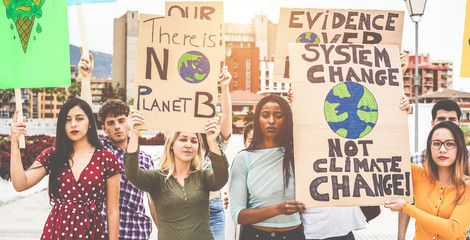 Group of demonstrators on road, young people from different culture and race fight for climate change - Global warming and enviroment concept - Focus on center girls faces