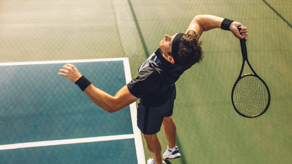 Tennis player serving in the match - obrazy, fototapety, plakaty