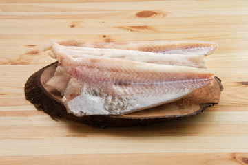 Frozen fillet of pangasius on wooden table