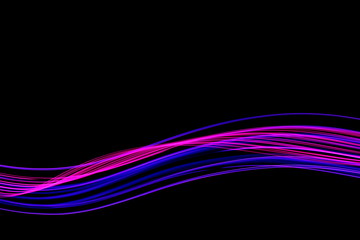 Long exposure, light painting photography.  Vibrant streaks of neon pink and purple color against a black background.