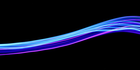 Long exposure, light painting photography.  Vibrant streaks of neon blue and pink color against a black background.