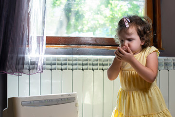 Little girl in a dusty room. Air purifier and coughing kid. Dust in the air. - 283179119