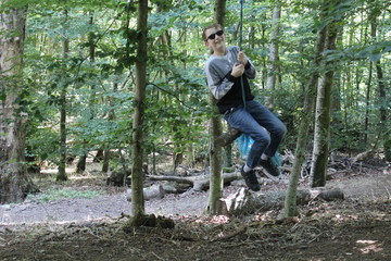 Young boy on a rope swing in forest