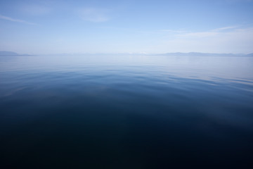 Fototapeta premium Blue Calm Ocean Water Meets Blue Sky at the Horizon