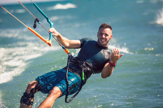 Kitesurfing. Man rides on kite on waves