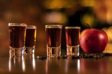 Fototapeta alkohol shots coffee beans and apple on bar table on blurred background obraz