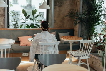 Young afro-american woman sitting inside city cafe