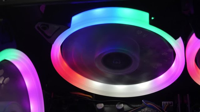 Cooling fans illuminated by LEDs inside personal computer. Desktop Gaming PC with multicolored RGB lights