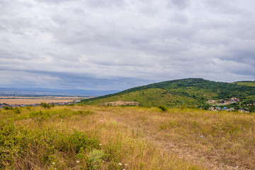 Southern highlands. Field with low mountains. Low mountains with trees. Anapsky district, Russia. Summer mountain landscape