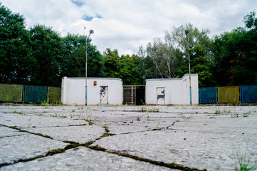  Old floor. Cracks and fractures on the surface. Grass grows through concrete.