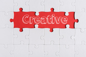 top view of connected jigsaw puzzle pieces near creative letters