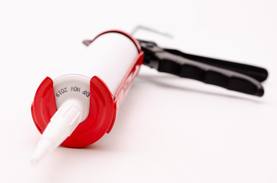 Caulking gun and white silicone sealant
