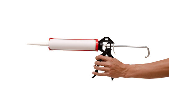 Men's hand holding Caulking gun and white silicone sealant