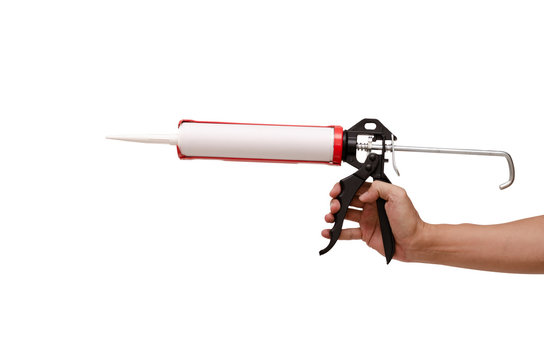 Men's hand holding Caulking gun and white silicone sealant