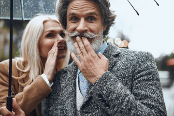 Positive couple sharing little secret stock photo