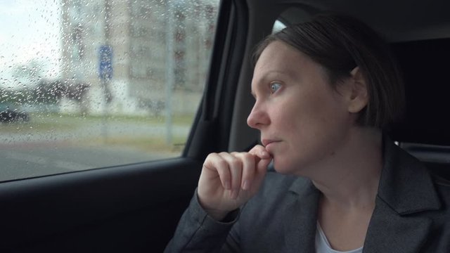Businesswoman waiting at car back seat, handheld footage