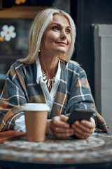 Peaceful woman with smartphone smiling stock photo