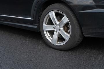 Obraz na płótnie Canvas Close-up of a wheel of a black car in movement
