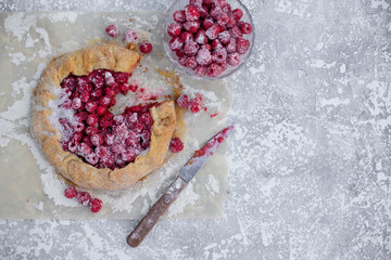 Homemade fruit pie (galette) made with fresh raspberries with powdered sugar on concrete...