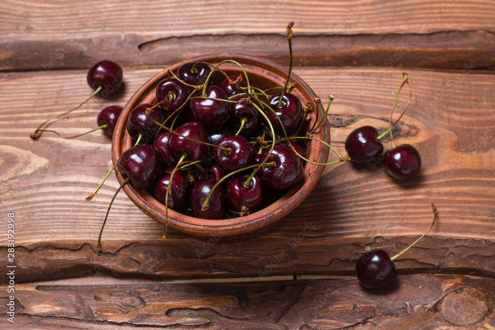 Wall mural Fresh sweet sweet cherry in a plate on a wooden background. - Wall murals
