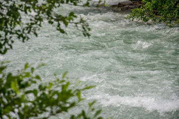 Obraz na płótnie Canvas Wild river of Rhone (Rotten) in alpine valley of Goms (Wallis) in Switzerland. A lot of water streaming in rapids.