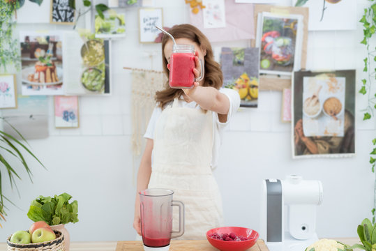 Beautiful girl holding a freshly made smoothie from berries. The concept of a healthy diet, healthy lifestyle.