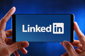 LinkedIn Insight Tag Hands holding smartphone displaying logo of LinkedIn