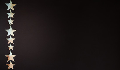 Minimal composition pattern of silver Christmas stars on dark background. New Year concept.